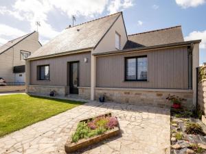 a home with a stone patio and a house at Holiday Home l'Emeraude by Interhome in Matignon