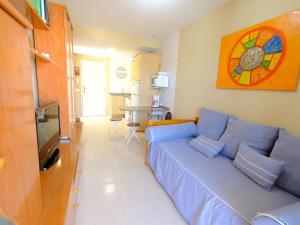 Una sala de estar con un sofá azul y una mesa. en Apartment Apartamento Duc Medinacelli by Interhome, en Hospitalet de l'Infant