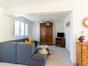 uma sala de estar com um sofá azul e uma televisão em Holiday Home l'Emeraude by Interhome em Matignon