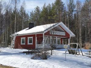 uma casa vermelha com um telhado coberto de neve na neve em Holiday Home Koivulahden reinola by Interhome em Raanujärvi