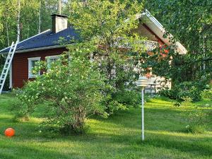 a house with a tree and an orange ball in the yard at Holiday Home Koivulahden reinola by Interhome in Raanujärvi