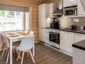 uma cozinha com uma mesa branca e cadeiras numa cozinha em Holiday Home Kolin kangastus apila 1 by Interhome em Kolinkylä