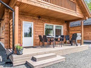 une cabane en bois avec une terrasse équipée d'une table et de chaises dans l'établissement Holiday Home Kolin kangastus apila 1 by Interhome, à Kolinkylä