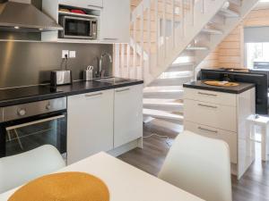 uma cozinha com armários brancos e uma escadaria em Holiday Home Kolin kangastus apila 1 by Interhome em Kolinkylä