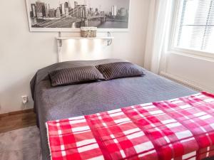 a bed with a red and white plaid blanket at Holiday Home Point vale 3 by Interhome in Tahkovuori