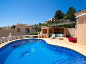 una piscina con due sedie e una casa di Holiday Home Castellons Vida by Interhome a Teulada