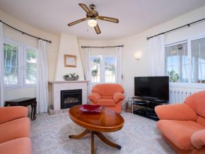 un soggiorno con sedie arancioni e TV di Holiday Home Castellons Vida by Interhome a Teulada