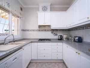 una cucina con mobili bianchi, un lavandino e una finestra di Holiday Home Castellons Vida by Interhome a Teulada Altre 19 foto