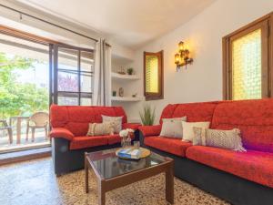 a living room with red couches and a table at Holiday Home Ibicenca by Interhome in Riumar