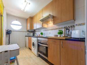 a kitchen with wooden cabinets and a dishwasher at Apartment Bosc de la Montserrada by Interhome in Salou