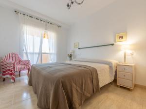 Apartment Bosc de la Montserrada by Interhome في سالو: غرفة نوم بسرير وكرسي ونافذة