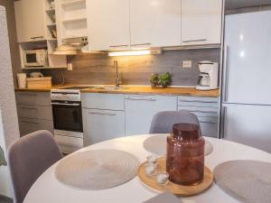 kuchnia ze stołem i krzesłami oraz kuchnia z białymi szafkami w obiekcie Holiday Home Rukaköngäs 21 by Interhome w mieście Ruka