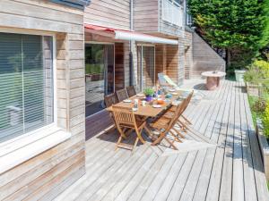 a wooden deck with a table and chairs on it at Holiday Home l'Agon by Interhome in Agon Coutainville