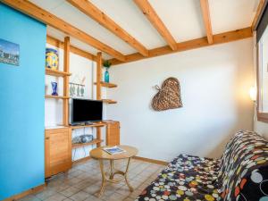 uma sala de estar com um sofá e uma televisão em Apartment Les Soleils Rouges-15 by Interhome em Vaux-sur-Mer