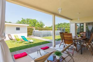 eine Terrasse mit Stühlen, einem Tisch und einem Hof in der Unterkunft Guest house Casa Dia in Labin