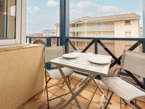 d'une table et de chaises blanches sur un balcon. dans l'établissement Apartment Les Hélianthes-2 by Interhome, à Lacanau-Océan