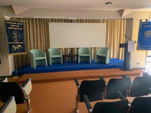 a meeting room with chairs and a white screen at Savant Hotel in Lamezia Terme