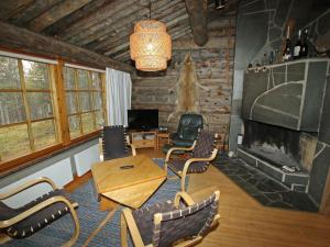 a living room with a table and chairs and a fireplace at Holiday Home Poromooli a1 by Interhome in Saariselka