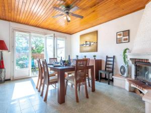 jadalnia ze stołem i krzesłami oraz wentylatorem sufitowym w obiekcie Holiday Home Les Violettes by Interhome w mieście Canet-en-Roussillon