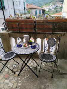 un tavolo con sedie e un piatto di cibo sul balcone di Casa Irma a Chiusavecchia