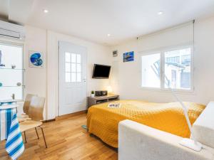 a bedroom with a bed and a couch and a tv at Apartment Jean Jaurès-2 by Interhome in Ciboure +19 photos