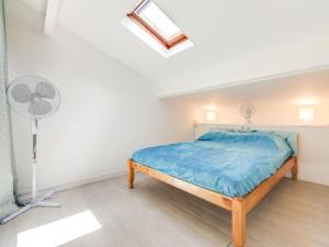 a small bedroom with a bed and a fan at Holiday Home Les mas Bleus by Interhome in Saint Cyprien Plage