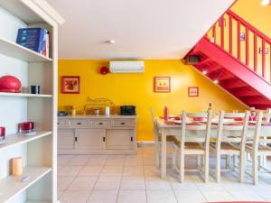 une cuisine avec des murs jaunes et une table avec des chaises dans l'établissement Apartment Antinéa by Interhome, aux Lecques