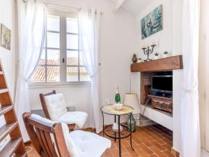 salon z kominkiem, stołem i krzesłami w obiekcie Studio Château de la Madrague-8 by Interhome w mieście Saint-Cyr-sur-Mer