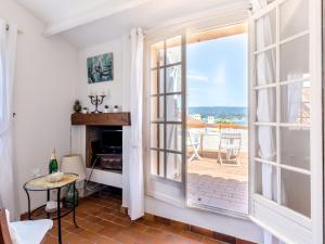 salon z kominkiem i dużym oknem w obiekcie Studio Château de la Madrague-8 by Interhome w mieście Saint-Cyr-sur-Mer