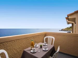 einen Tisch mit Getränken auf einem Balkon mit Meerblick in der Unterkunft Apartment Les Roches Bleues-7 by Interhome in Collioure