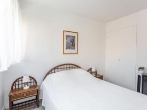 1 dormitorio blanco con 1 cama y 2 mesitas de noche en Apartment Le Cormoran by Interhome, en Le Lavandou