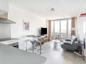 cocina blanca con mesa y sala de estar en Apartment Le Cormoran by Interhome, en Le Lavandou