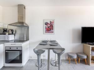una cocina con mesa y taburetes. en Apartment Le Cormoran by Interhome, en Le Lavandou
