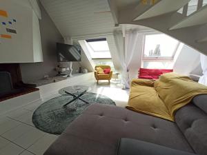 Superbe loft 90m² proche parc expo Nantes (6p) في نانت: غرفة معيشة مع أريكة وطاولة