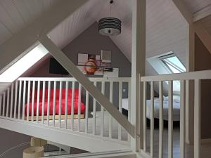 Superbe loft 90m² proche parc expo Nantes (6p) في نانت: غرفة في العلية مع درج وأريكة حمراء