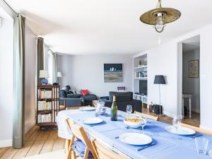 a living room with a large blue table with chairs at Apartment La Vigie by Interhome in Cancale
