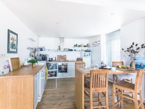 a kitchen with white cabinets and a table and chairs at Apartment La Vigie by Interhome in Cancale +20 photos