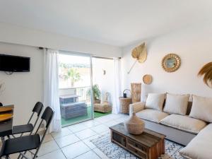 una sala de estar con un sofá y una mesa en Apartment La Méridienne-5 by Interhome, en Le Lavandou