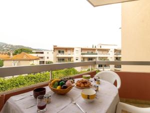 a table with a bowl of fruit on a balcony at Studio Le Grand Foc-3 by Interhome in Cavalaire-sur-Mer