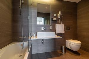 a bathroom with a tub and a toilet and a sink at Monchique Resort & Spa in Monchique