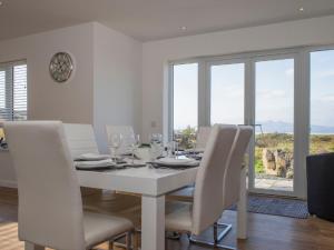 - une salle à manger blanche avec une table et des chaises blanches dans l'établissement Holiday Home Joan's House by Interhome, à Tarskavaig