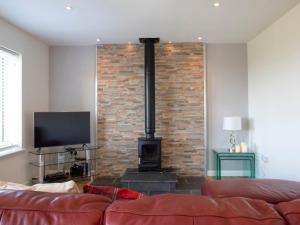 a living room with a brick wall and a fireplace at Holiday Home Joan's House by Interhome in Tarskavaig