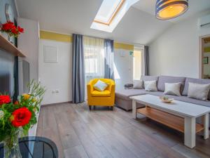 salon z kanapą i żółtym krzesłem w obiekcie Holiday Home Veli by Interhome w mieście Veli Brgud