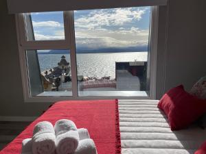 sypialnia z oknem wychodzącym na wodę w obiekcie Acqua Apartments Bariloche w mieście Bariloche