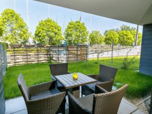 a table and chairs on a patio with a fence at Apartment Marianna by Interhome in Balatonszemes