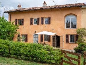 una casa naranja con una valla delante de ella en Holiday Home Casa Vicentini by Interhome, en Alfiano Natta