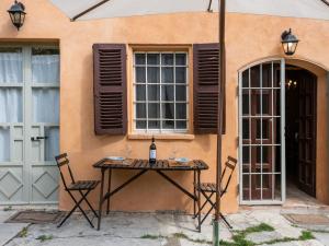 una mesa con una botella de vino sentada junto a un edificio en Holiday Home Casa Vicentini by Interhome, en Alfiano Natta