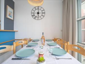 jadalnia ze stołem, krzesłami i zegarem w obiekcie Apartment Hameau - N1 208 by Interhome w mieście Agay - Saint Raphael
