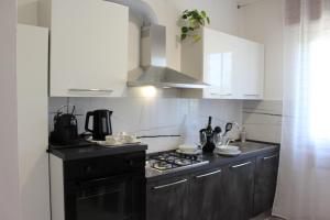 a kitchen with a black stove and white cabinets at B&B Fili d'erba in Farra dʼlsonzo