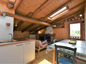 a kitchen and dining room with wooden ceilings and a table at Apartment Nido dello Stelvio by Interhome in Pezzo